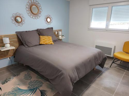 ein Schlafzimmer mit einem großen Bett und einem gelben Stuhl in der Unterkunft Maison ROSAE Betula 