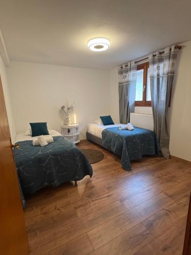 two beds in a room with wooden floors at Gîte au cœur du vignoble in Riquewihr