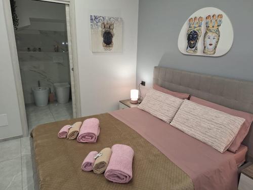 ein Schlafzimmer mit einem Bett mit rosa Handtüchern darauf in der Unterkunft Casa vacanze al teatro in Catania
