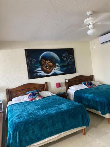 a bedroom with two beds and a painting on the wall at Cancun Condo & Resort in Cancún