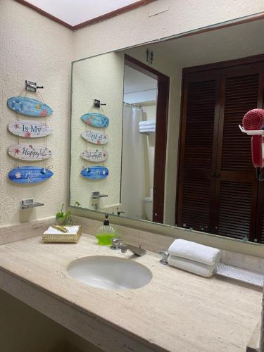 a bathroom with a sink and a large mirror at Cancun Condo & Resort in Cancún