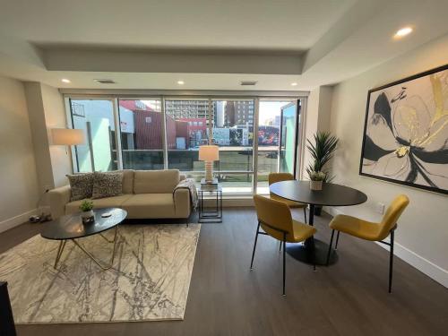 a living room with a couch and tables and chairs at Downtown bright & cozy 1 BR with 6 appliances in Halifax