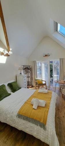 a bedroom with a large bed with two pillows on it at Ty Heulwen Studio in St. Davids