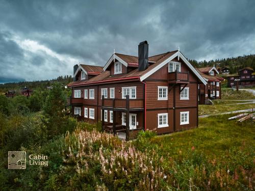 トリシルにあるNice apartment in Trysil ski in-out, sauna and viewの草原の大木造家屋