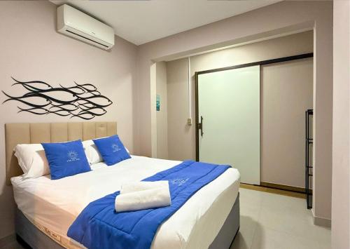 a bedroom with a large bed with blue and white pillows at Luxo Frente Mar em 7 Qtos com Ar sendo 4 suites para até 18 pessoas, 2 Jacuzzi Aquecidas, piscina, brinquedoteca, 5min de Castelhanos in Anchieta