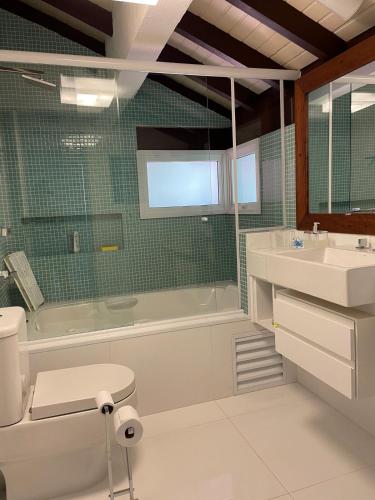 a bathroom with a tub and a toilet and a sink at Paradise at your feet in São Sebastião