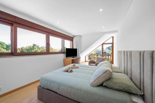 a bedroom with a large bed with windows at Terra Nossa in Vila Real