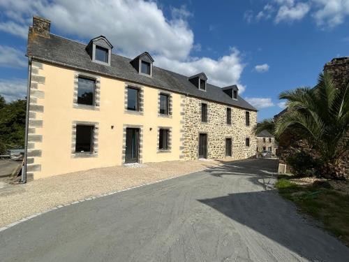 a large white building with a black roof at Bleu horizon in Rosnoën