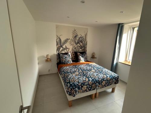 a bedroom with a bed with a floral bedspread at Bleu horizon in Rosnoën