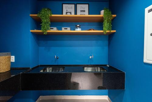 a kitchen with a black counter and blue walls at Apto Novo Centro SP Com Vista Panorâmica in Sao Paulo