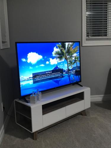 a flat screen tv sitting on a white entertainment center at Point Peel Haven Retreat in Leamington