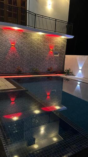 a swimming pool with red lights in a building at Moonlit resort in Minuwangoda