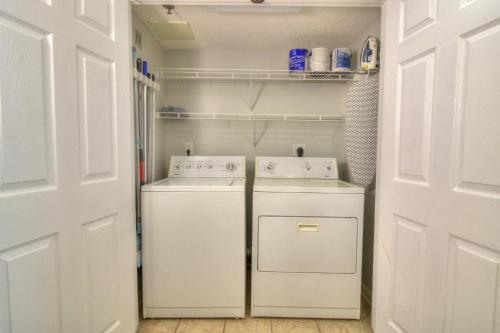 a white laundry room with a washer and dryer at Crescent Shores North - 502 in Myrtle Beach