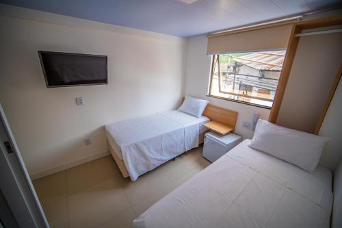 a small room with two beds and a window at Amazinn Hotel in Belém
