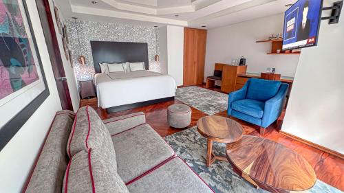 a living room with a bed and a couch and a table at Santa Rita Hotel del Arte in Zacatecas