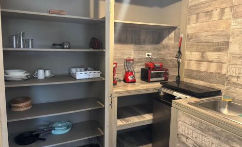 eine Küche mit Holzregalen und einem Waschbecken in der Unterkunft Suite 3 del Centro de Cuauhtémoc Chihuahua in Cuauhtémoc