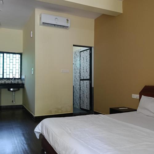a bedroom with a white bed and a window at One love guest house morjim in Arambol