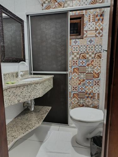 a bathroom with a shower with a toilet and a sink at Hospedagem Quinta do Correia in Penha