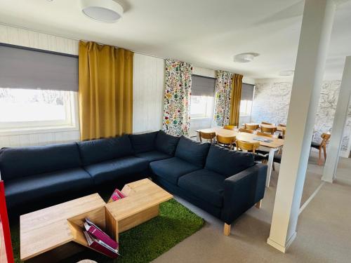 un salon avec un canapé bleu et une table dans l'établissement Kittelfjäll Vandrarhem, à Kittelfjäll