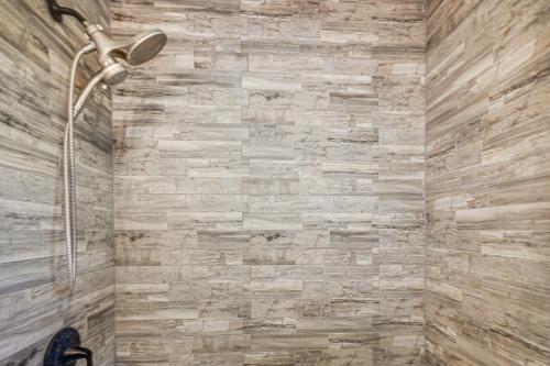 a bathroom with a shower with a stone wall at 2 Mi to Pewaukee Lake! Peaceful Retreat with Yard in Pewaukee