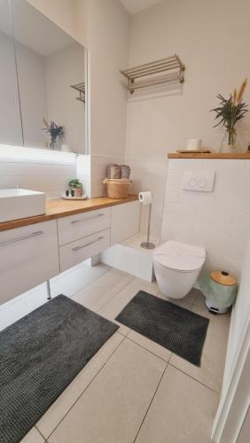a bathroom with a toilet and a sink and a mirror at Escape The Ordinary in Bucharest