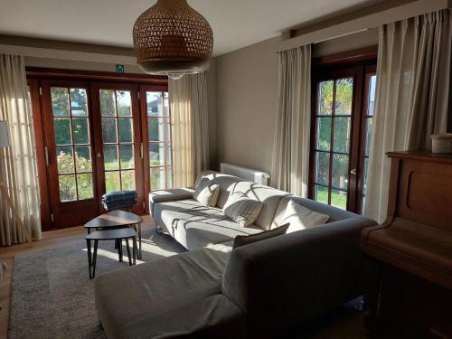 a living room with a couch and a table at Domein 15 De Haan Nieuwmunster, 4-bedroom holiday house for up to 6 people, between Wenduine, 1 km, and De Haan, 2 km, 500 meters from the beach,15 min from Bruges, Ostend and Knokke, nice fenced garden, no services offered in Zuienkerke