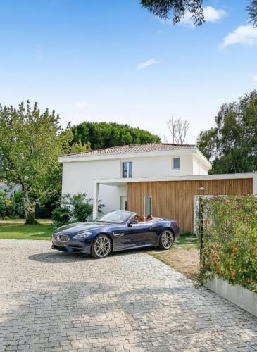 a blue car parked in front of a house at Villa calme avec piscine et spa à Mérignac Proche hôpital tram et parc d activité in Mérignac