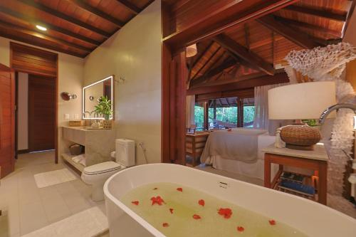 a bathroom with a bath tub in a room at Anttunina Pousada e SPA in Maragogi