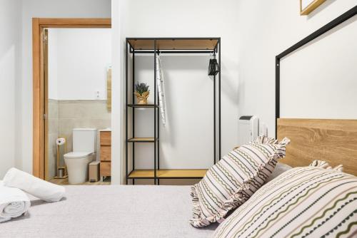 ein Schlafzimmer mit einem Bett und ein Badezimmer mit einer Toilette in der Unterkunft Casa Príncipe Pío in Madrid