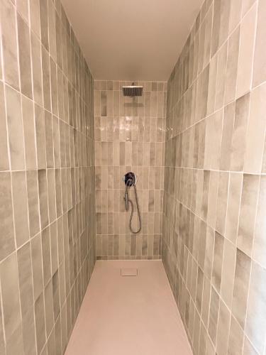 a bathroom with a shower with tiled walls at Longère de charme au vert in Cessières