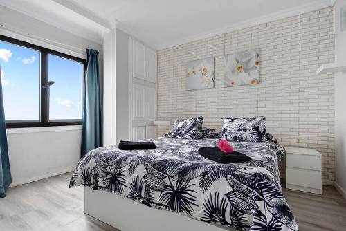 ein Schlafzimmer mit einem Bett mit einer schwarz-weißen Bettdecke in der Unterkunft Casita Independiente Frente al Mar in El Pris