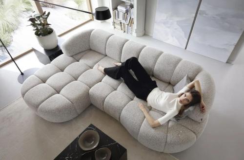 a woman laying on a couch in a living room at Louise Delux- Free privat parking in Nyíregyháza
