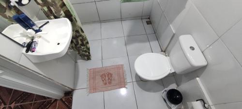 a small bathroom with a toilet and a sink at Shantti House in Pipa