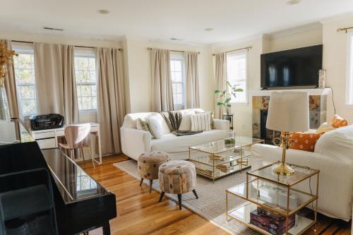 a living room with a white couch and a table at Urban Downtown Stamford Home 45 min to NYC with Garage And Yard in Stamford