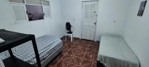 a bedroom with a bed and a table and a chair at Shantti House in Pipa