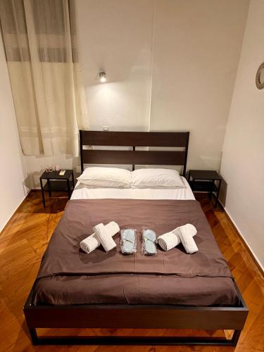 a large bed with two towels and two shoes on it at Blue Note in Mytilene