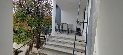 a staircase leading to a house with a table and chairs at Anna apartman in Niš