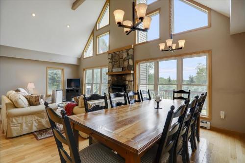 a dining room with a wooden table and chairs at Four Seasons Chalet in Waterbury Center