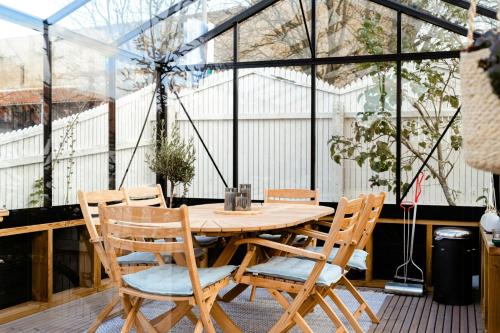 a wooden table and chairs in a greenhouse at True Skagen House From 1870 By The West Coast in Skagen