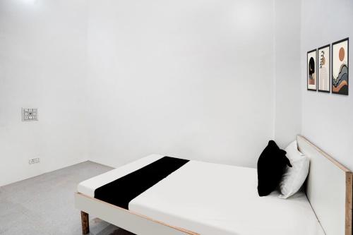 a white bedroom with a black and white bed at Hotel O Wave Inn in Jahāngīrpur