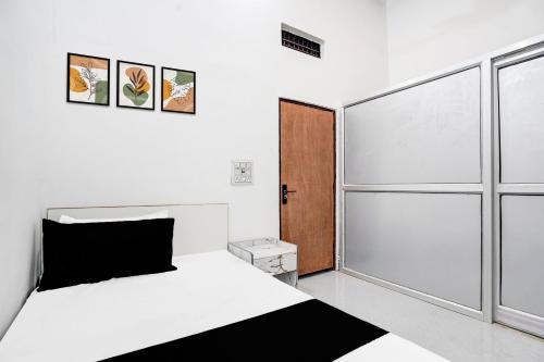 a bedroom with a white bed and a sliding door at Hotel O Wave Inn in Jahāngīrpur