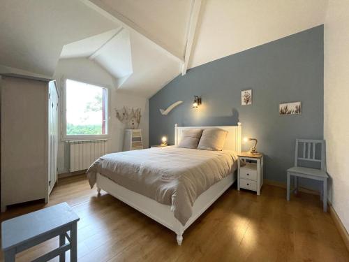 Un dormitorio con una cama blanca y una pared azul. en Otxibarre, en Luxe-Sumberraute