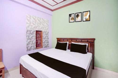 a bedroom with a bed in a room at HOTEL O AWARA GRAND PALACE in Pratāpgarh