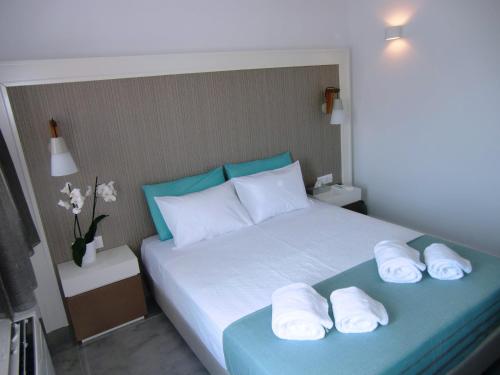 a bedroom with a bed with towels on it at Platia in Fira
