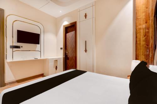 a bedroom with a white bed and a mirror at Hotel O Parth in Ayodhya