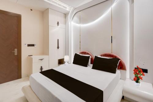 a bedroom with a white bed with two red chairs at Hotel O Parth in Ayodhya