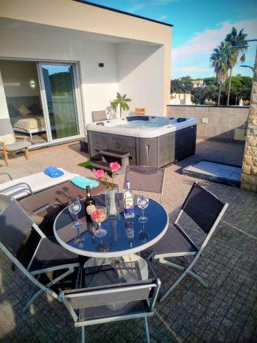 a patio with a table and chairs and a hot tub at Villa Luz 37 - Jacuzzi Terrace & Swimming Pool in Albufeira