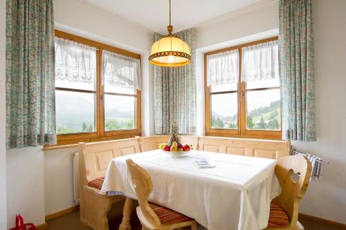 a dining room with a table and two windows at Haus Kristina in Riezlern