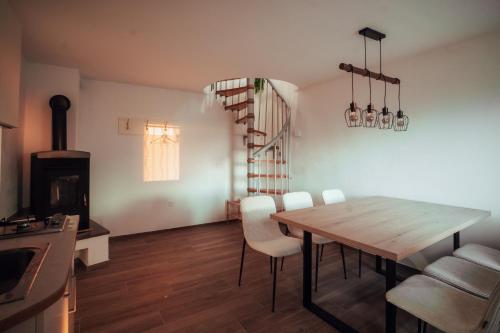 a kitchen and dining room with a wooden table and chairs at SkyView Dežno in Makole