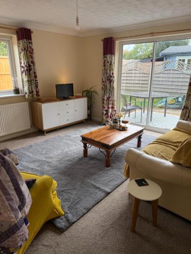 East HarlingにあるThe Wright Midweek stayのソファとコーヒーテーブルのあるリビングルーム